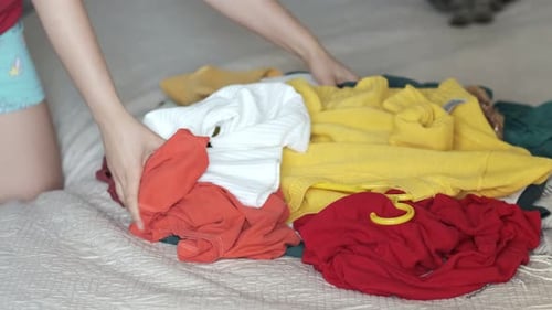 Hands Sorting Through Pile of Colorful Clothing