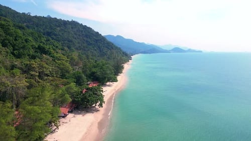 Huts on tropical island beach in rainforest. Fabulous aerial view flight drone