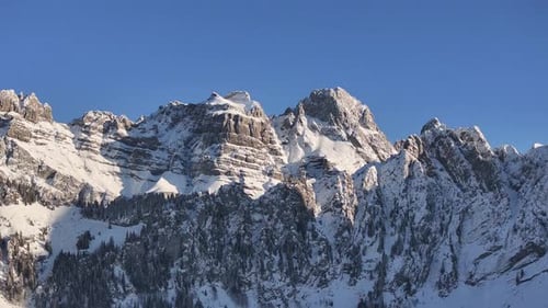 oaring aerial view showcases the majestic Fronalpstock mountain range in Glarus, Switzerland.