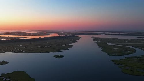 An aerial view high over the salt marsh off Freeport, NY during a colorful sunrise.