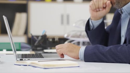 Man Working on Laptop in a Clean Office