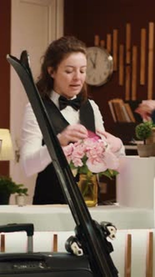 Staff Assist Guests at Hotel Reception Desk