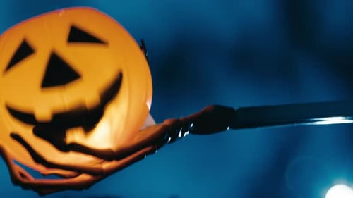 Skeleton Hand Holding Halloween Pumpkin