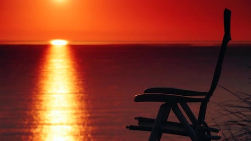 Camp Chair On Beach And Sunrise Over Sea