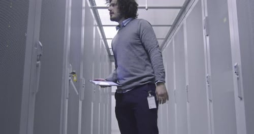 Man Working in Modern Data Center With Tablet