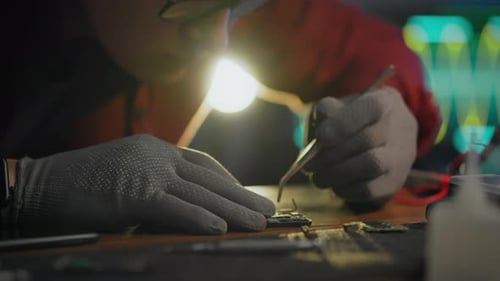 Technician Repairs Cell Phone with Tweezers