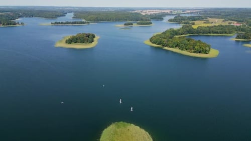 A view of forested islets on the blue waters of the lake and a forest on the shore