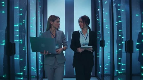 Women Walking Through Futuristic Data Center