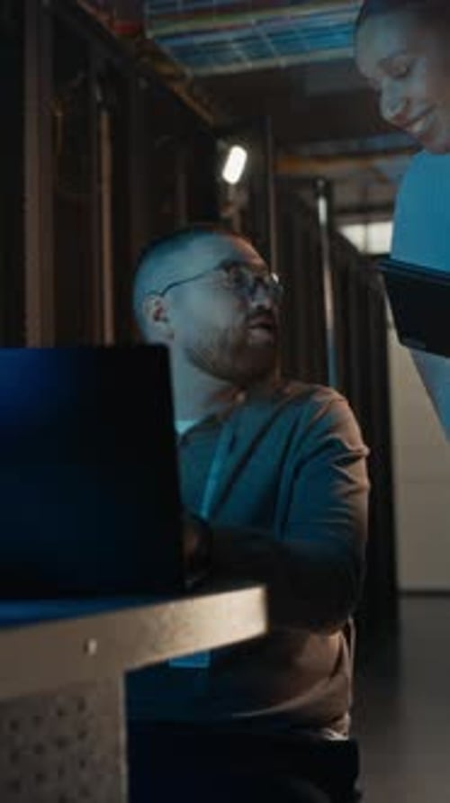 Data Center Specialist Communicating with Female Colleague in Server Room