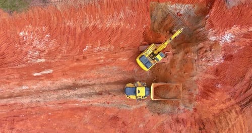 Excavator Loading Dump Truck from Aerial View
