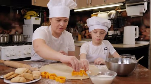 Woman and Child Baking Cookies Together in Kitchen