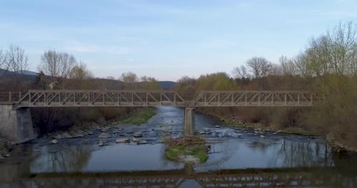 Drone Shot flying over a Bridge above a River at Sunset, 4k UHD