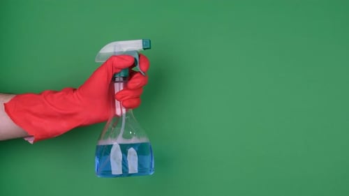 Hand Holds Spray Bottle with Blue Liquid