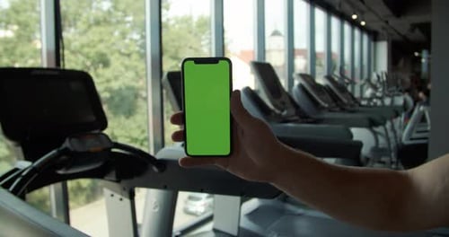 Back View of Fitness Man Using Green Screen Smart Phone at Home Man Preparing for Workout Using