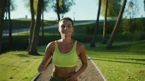 Woman Running on Path in Park on Sunny Day