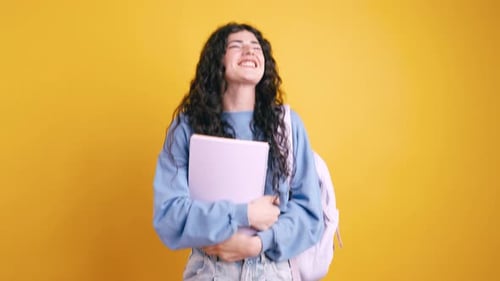Smiling Student Girl Holding Books and Backpack in Studio
