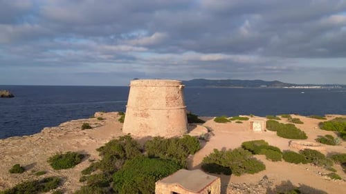 mediterranean coastal sunset ancient historic tower. Magic aerial top view flight fly reverse drone