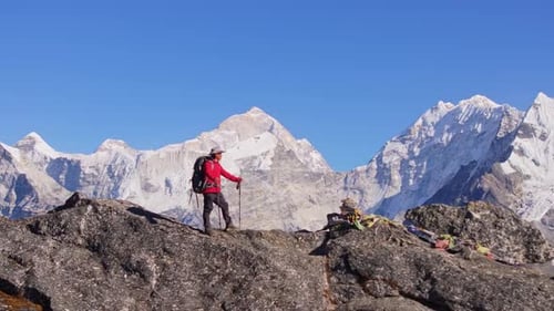 Aerial View of a Mountaineer Standing on a Rocky Summit in Nepal Enjoying the Breathtaking Panorama