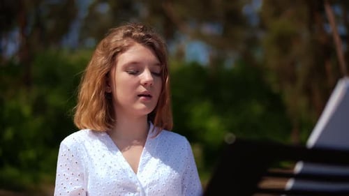 Woman Singing and Playing Electronic Keyboard Outdoors