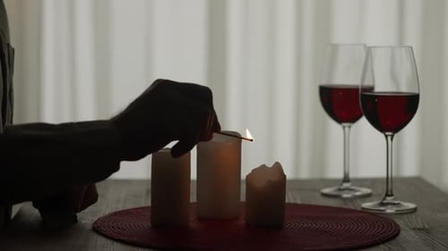 Romantic Evening By Candlelight Hands of a Man Lighting Candles with Matches Close Up Burning