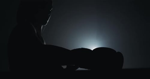 Woman Boxing in Dark Gym with Gloves