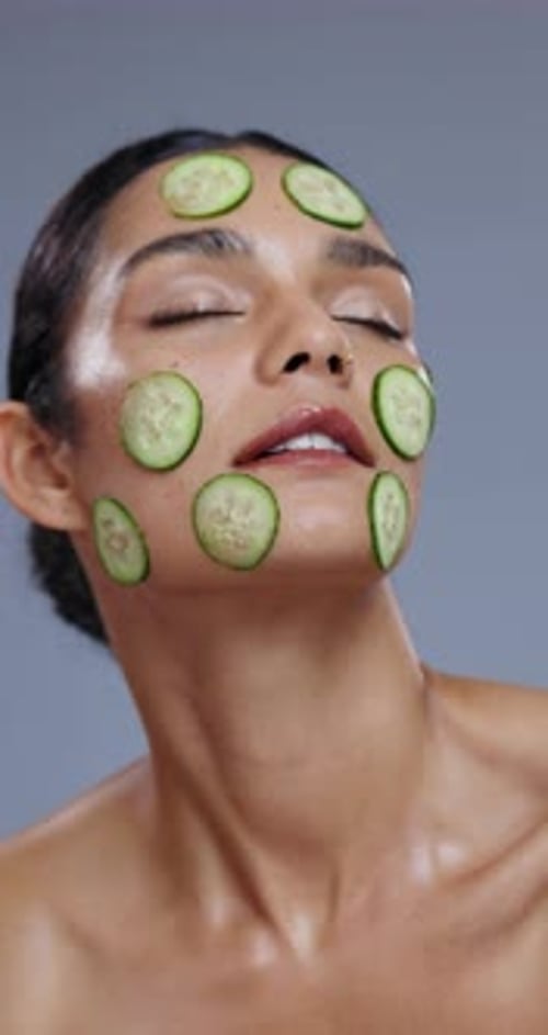 Woman Posing with Cucumber Slices on Face