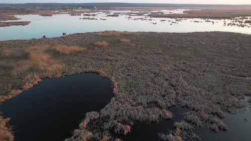 Serene wetland with scattered water bodies at sunset, aerial view