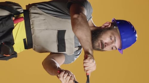 Vertical Video Construction Craftsman Working with Steel Wrench on Renovation