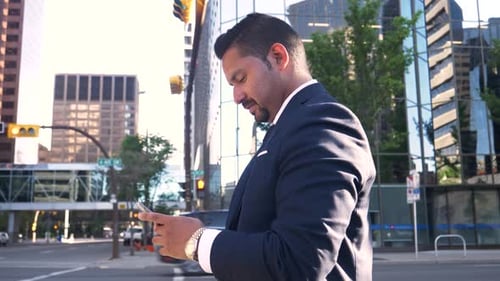 Businessman in Suit Using Smart Phone on City Street Corner Adult