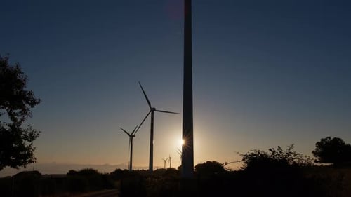 Silhouette von Windgeneratoren und Stromerzeugung bei Sonnenaufgang