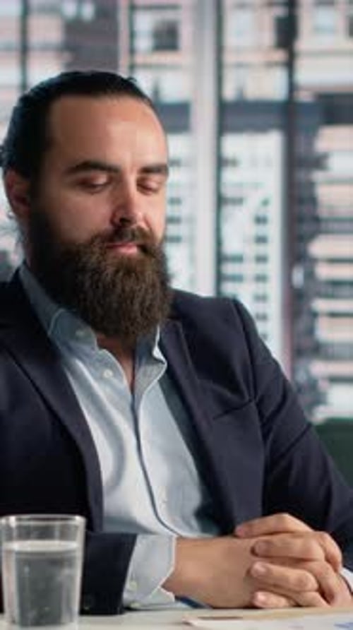Thoughtful Businessman Reviews Documents in an Office