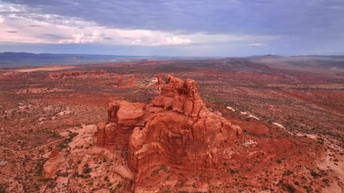 Flying closer to red unapproachable rock in the dry desert.