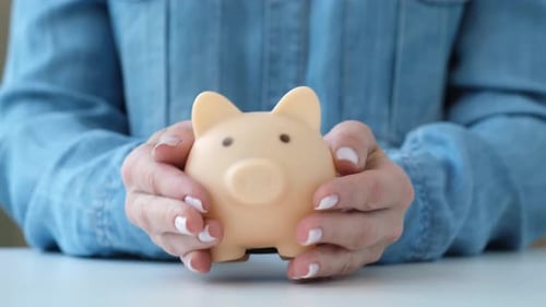 Woman Picks Up a Piggy Bank Saving Money Wealth and Financial Planning Concept