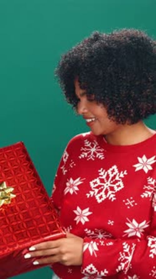 Christmas, gift and face of woman with guess for holiday, tradition and festive season in studio