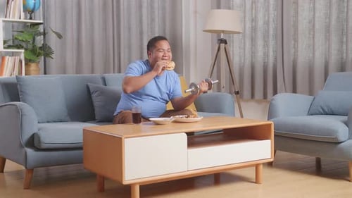 Adult Lifting Weights While Eating Fast Food