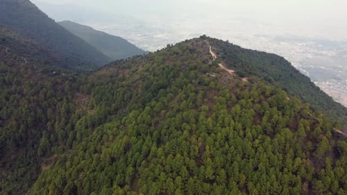 An aerial flight over the forested foothills of the Himalaya Mountains in Nepal.