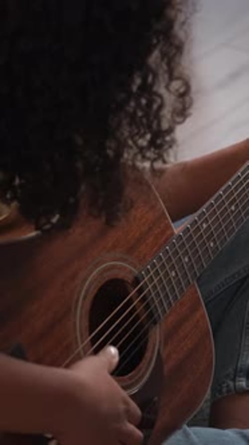 Young Adult Plays Acoustic Guitar Indoors