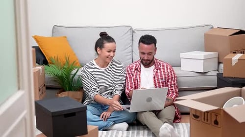 Happy Couple in New Home With Moving Boxes