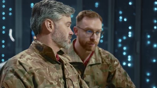 Men Wearing Camouflage Working at Computer in Dark Office