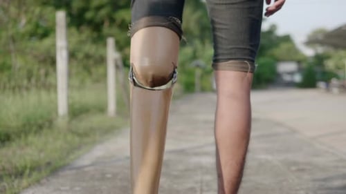 Man Walking Outdoors With Prosthetic Leg