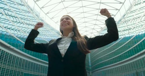 Successful Woman Celebrating in Front of Modern Building