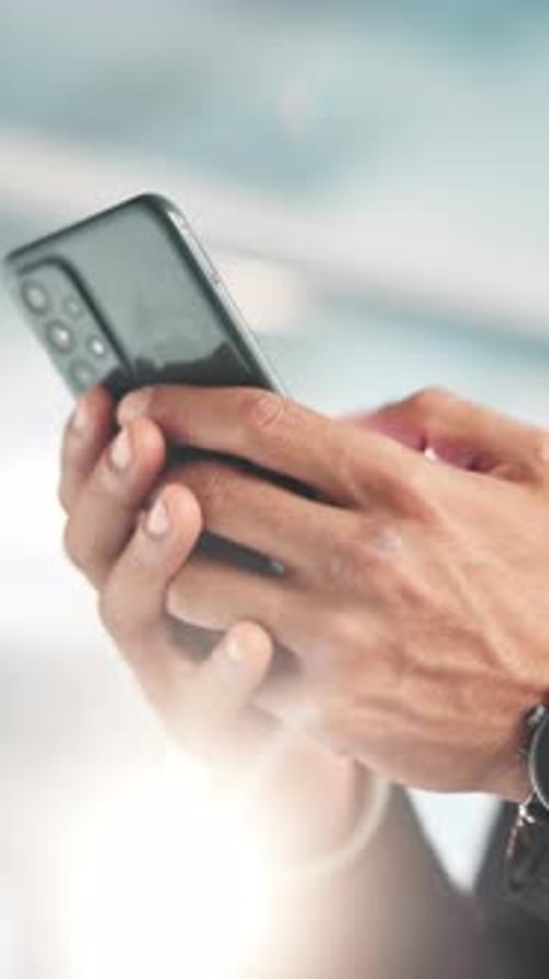 Hands Hold Phone in City Setting