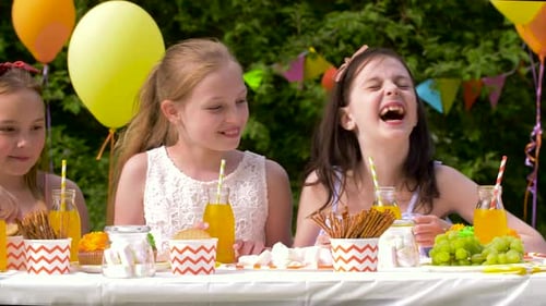 Happy hispanic children celebrate a summer birthday party in the garden yard
