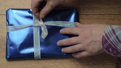 Hands Untying Ribbon on Beautifully Wrapped Gift