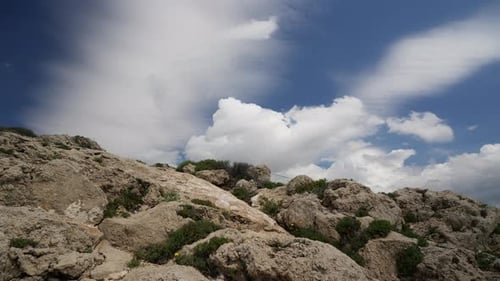 Timelapse of a large cumulus clouds on top of a rocky mountain