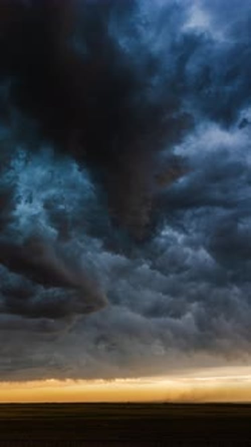 Dark Storm Clouds Rolling Across Golden Horizon at Sunset