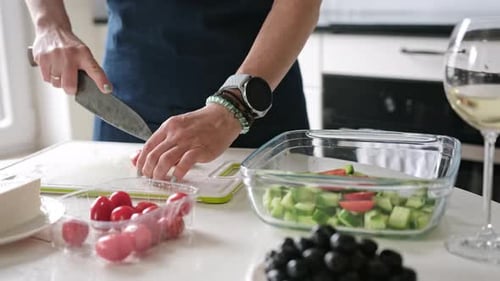 Person cuts tomatoes for a fresh salad