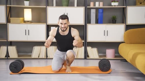 Man Kneeling on Yoga Mat Celebrates Fitness Success