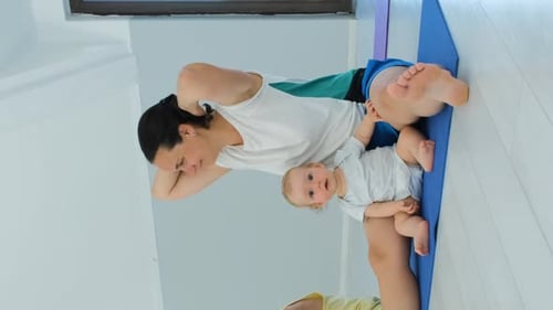 Woman Does Crunches With Baby On Lap