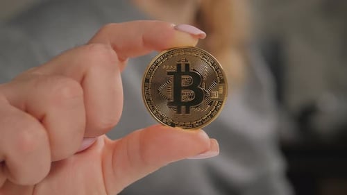 Hand Holding Golden Bitcoin Cryptocurrency Coin Close Up